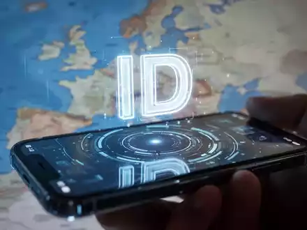 A glowing digital ID icon over a smartphone screen, with a blurred map of Europe in the background, symbolizing digital identity and banking. - Foto: über boerse-global.de