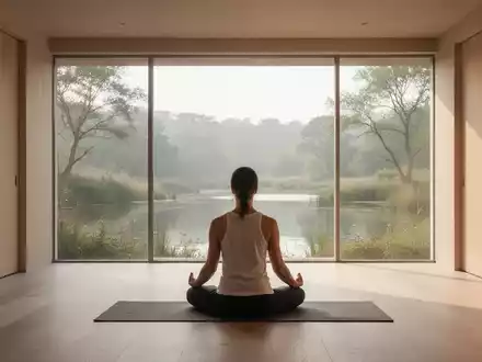 Ein ruhiger Meditationsraum mit großen Fenstern und Blick auf eine friedliche Naturlandschaft, symbolisiert Entspannung und Achtsamkeit. - Foto: über boerse-global.de