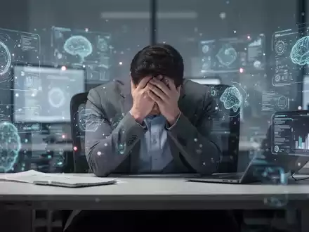 Eine Person sitzt am Schreibtisch, den Kopf in den Händen, umgeben von verschwommenen digitalen Schnittstellen, die Überforderung symbolisieren. - Foto: über boerse-global.de