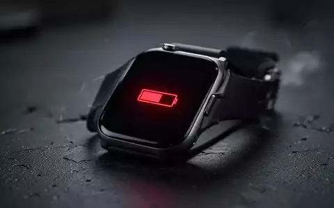 Eine Nahaufnahme einer modernen Smartwatch mit einem Symbol für niedrigen Batteriestand auf dem Bildschirm, der eine schnelle Entladung anzeigt. - Foto: über boerse-global.de