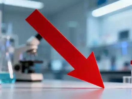 Ein roter Abwärtspfeil über einem unscharfen Bild eines Pharma-Forschungslabors, der einen starken Aktienkursrückgang symbolisiert. - Foto: über boerse-global.de
