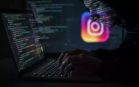 A person's hands typing on a laptop keyboard, with code reflecting on their face, and a blurred Instagram logo in the background. - Foto: über boerse-global.de