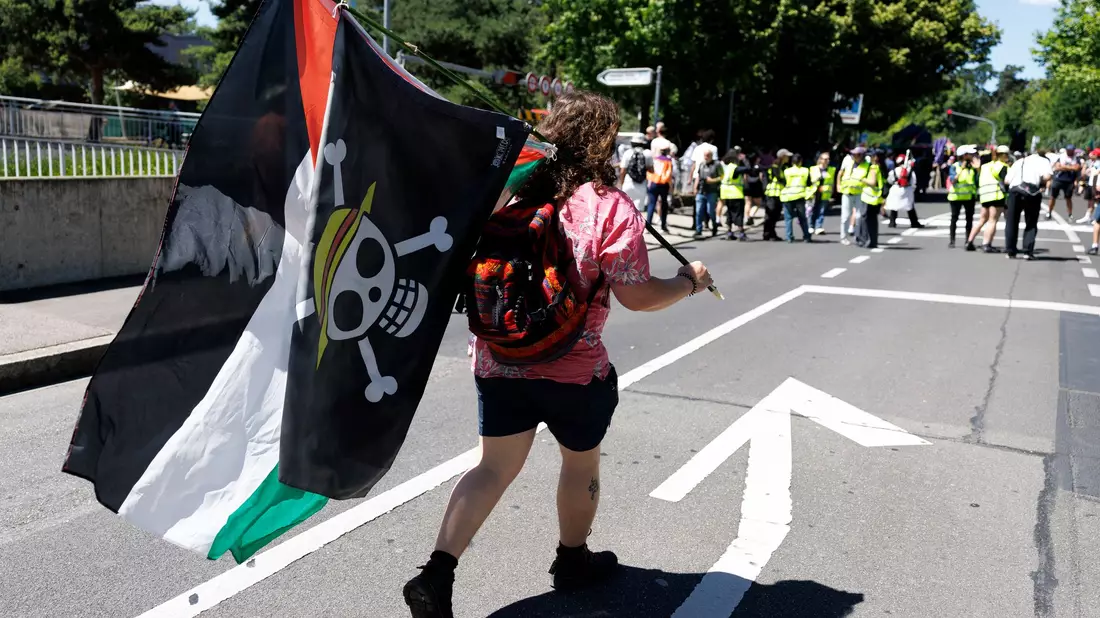 Im Protestzug sind viele Palästinenserflaggen zu sehen. - Bild: Cyril Zingaro/KEYSTONE/dpa