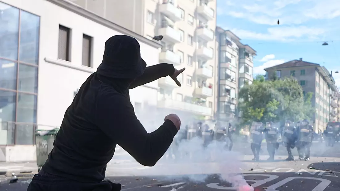 In Genf kommt es bei Protesten gegen den G7-Gipfel in Évian zu Auseinandersetzungen zwischen Demonstranten und der Polizei. - Bild: Michael Kappeler/dpa