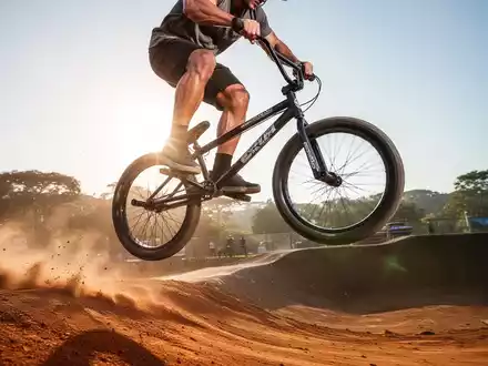 Ein BMX-Fahrer springt dynamisch auf einer Dirt-Strecke, seine Muskulatur ist sichtbar und vermittelt Kraft und Explosivität. - Foto: über boerse-global.de