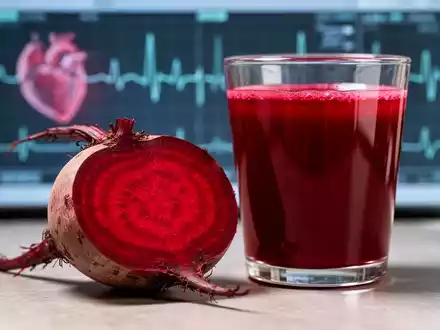 Eine aufgeschnittene rote Bete neben einem Glas Rote-Bete-Saft, im Hintergrund verschwommen medizinische Diagramme. - Foto: über boerse-global.de