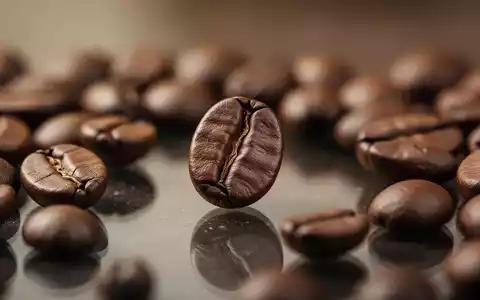 Nahaufnahme einer einzelnen Kaffeebohne, umgeben von weiteren Kaffeebohnen auf einer glänzenden Oberfläche. - Foto: über boerse-global.de