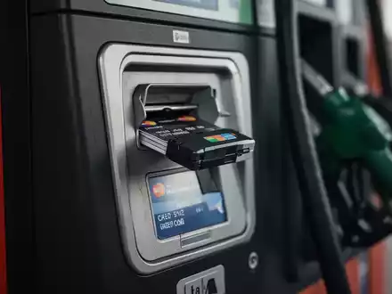 Nahaufnahme eines manipulierten Kartenlesers an einer Tankstelle, der auf Betrug und Skimming hinweist. - Foto: über boerse-global.de