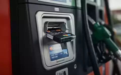Nahaufnahme eines manipulierten Kartenlesers an einer Tankstelle, der auf Betrug und Skimming hinweist. - Foto: über boerse-global.de