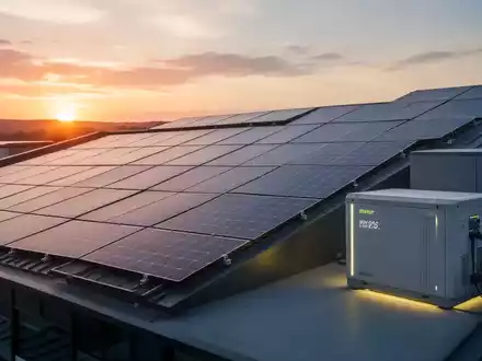 Solarpaneele auf einem modernen Dach bei Sonnenuntergang, mit einem Batteriespeicher, der subtil leuchtet. - Foto: über boerse-global.de
