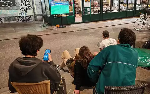Interessierte schauen nachts auf der Straße Fußball-WM 2026 - Foto: via dts Nachrichtenagentur