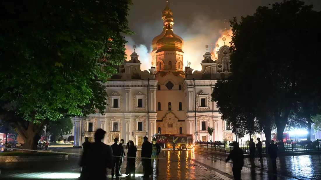 Flammen züngeln aus dem Dach unter den vergoldeten Kuppeln der Mariä-Entschlafens-Kathedrale.  - Bild: Danylo Antoniuk/AP/dpa
