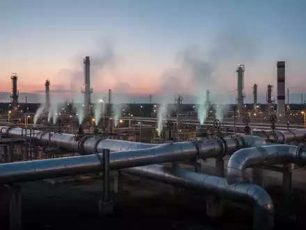 Industrielle Gaspipeline-Infrastruktur bei DĂ€mmerung, mit subtil entweichenden Methanfahnen, aus leicht erhöhter Perspektive. - Foto: ĂŒber boerse-global.de