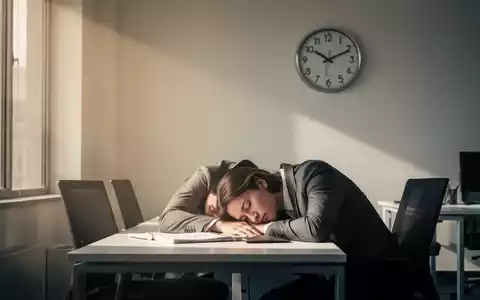 Eine Person ruht friedlich ihren Kopf auf einem Schreibtisch in einem hellen Büro, das einen Powernap am frühen Nachmittag darstellt. - Foto: über boerse-global.de