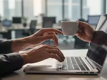 Hände, die eine kurze Pause von der Laptop-Arbeit machen, vielleicht strecken oder eine Tasse Kaffee halten, in einem modernen Büro. - Foto: über boerse-global.de
