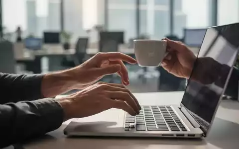 Hände, die eine kurze Pause von der Laptop-Arbeit machen, vielleicht strecken oder eine Tasse Kaffee halten, in einem modernen Büro. - Foto: über boerse-global.de