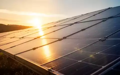 Solarpaneele bei Sonnenaufgang, die goldenes Licht reflektieren und frisches Kapital im Bereich erneuerbare Energien symbolisieren. - Foto: über boerse-global.de