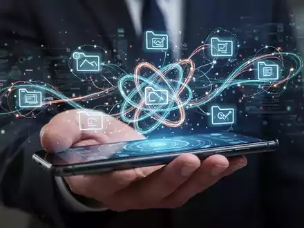 A hand holds a smartphone displaying a holographic interface of interconnected files and data streams, symbolizing complex digital management. - Foto: über boerse-global.de