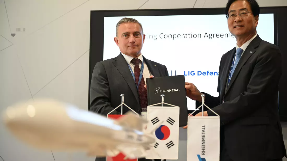 Rheinmetall-Manager Oliver Dürr und der südkoreanische Manager Ickhyun Shin nach der Unterschrift der Vereinbarung bei der Eurosatory. - Bild: Wolf von Dewitz/dpa