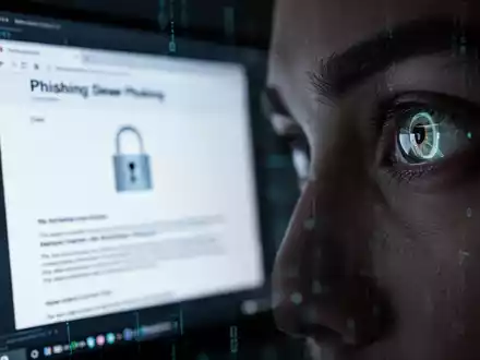 A close-up of a computer screen showing a phishing email reflected in a person's eye, symbolizing cyber threats and scams. - Foto: über boerse-global.de