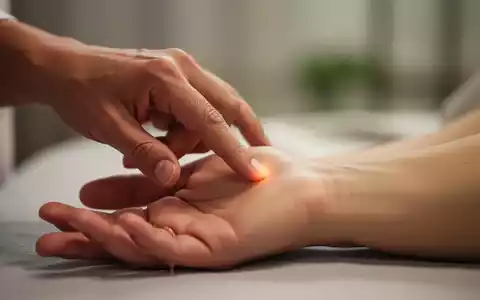 Eine Hand übt sanften Druck auf einen Akupunkturpunkt am Handgelenk einer anderen Person aus, in einer ruhigen, therapeutischen Umgebung. - Foto: über boerse-global.de
