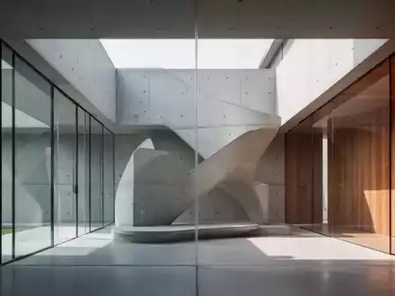 Eine moderne minimalistische Villa mit klaren Linien, großen Glasflächen und Sichtbeton, umgeben von Natur. - Foto: über boerse-global.de
