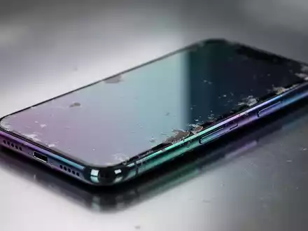 A close-up of a smartphone's metallic back, displaying subtle color fading on its surface, indicating wear. - Foto: über boerse-global.de