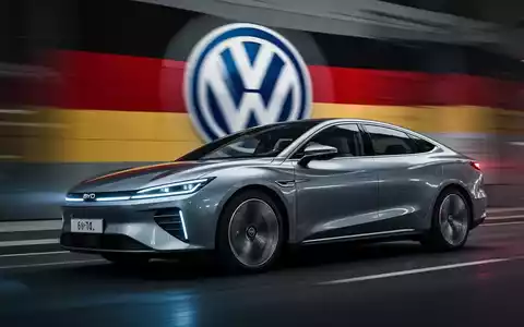 Ein modernes BYD Elektroauto fährt an einem verschwommenen deutschen Autohersteller-Logo vorbei, das einen Marktwandel symbolisiert. - Foto: über boerse-global.de