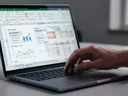Hand using a laptop with a professional Excel spreadsheet open, showing data and drop-down menus. - Foto: über boerse-global.de
