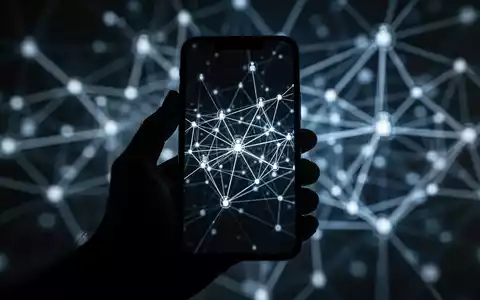 Eine dunkle, stilisierte Hand hält ein Smartphone, dessen Bildschirm mit abstrakten, vernetzten Linien und Knoten leuchtet, die ein Botnet symbolisieren. - Foto: über boerse-global.de