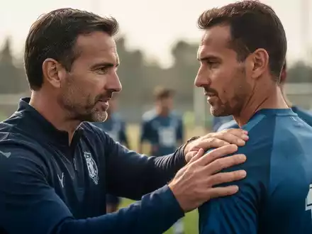 Nahaufnahme einer Trainerhand auf der Schulter eines Fussballspielers, symbolisiert Vertrauen und Führung im Sport. - Foto: über boerse-global.de