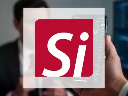 Hand hält Smartphone mit fallendem Aktienkurs, im Hintergrund unscharfe Person. Symbolisiert massiven CEO-Verkauf. - Foto: über boerse-global.de