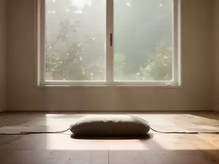 Ein ruhiger Meditationsraum mit einem einzelnen Kissen auf einem Holzboden, weiches natürliches Licht fällt durch ein großes Fenster. - Foto: über boerse-global.de