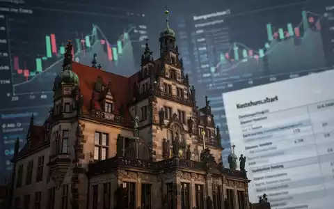 Nahaufnahme der Fassade eines historischen Rathauses, im Hintergrund unscharfe Finanzdiagramme und digitale Steuerformulare. - Foto: über boerse-global.de