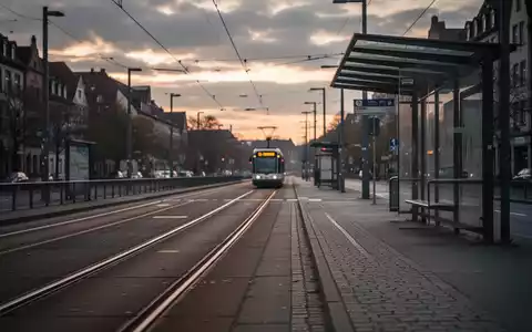 Leere Straßenbahnschienen und eine verlassene Bushaltestelle in Ulm bei bewölktem Himmel, symbolisch für einen Streik im Nahverkehr. - Foto: über boerse-global.de
