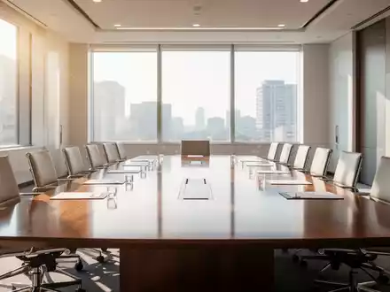 Ein moderner Konferenzraum mit einem großen Holztisch und leeren Stühlen, bereit für eine Hauptversammlung. - Foto: über boerse-global.de