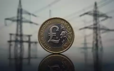 Eine britische Pfundmünze im Vordergrund, im Hintergrund verschwommene Stromleitungen und Versorgungsinfrastruktur. - Foto: über boerse-global.de
