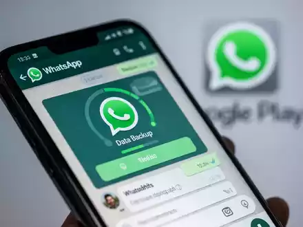 A smartphone screen showing WhatsApp chats and a blurred Google Play Store logo in the background, symbolizing mobile updates and data management. - Foto: über boerse-global.de