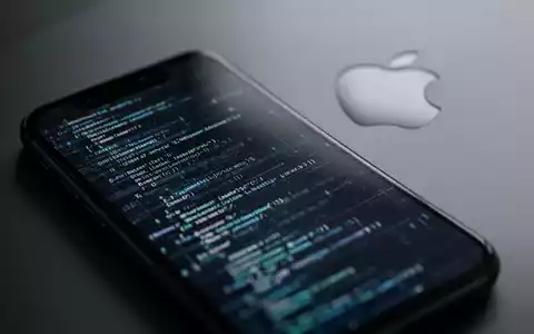 Close-up of an iPhone screen showing abstract code, with a subtle Apple logo in the background, symbolizing software updates. - Foto: über boerse-global.de