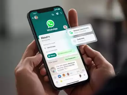 A close-up of a smartphone screen showing the WhatsApp app with its redesigned 'About' section and new floating message menu. - Foto: über boerse-global.de