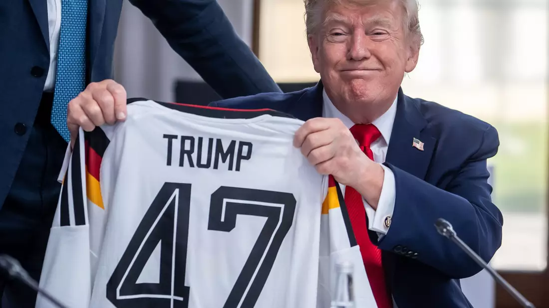 Trump zeigt sein Geschenk zum 80. Geburtstag.  - Bild: Michael Kappeler/dpa-Pool/dpa