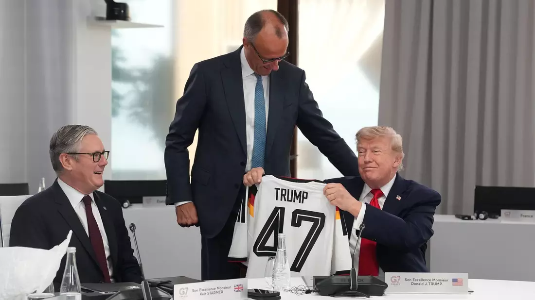 Im Sitzen nahm der US-Präsident sein Geschenk entgegen.  - Bild: Thibault Camus/Pool AP/AP/dpa
