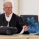 Der Verteidiger brachte für eine Analyse Kleidungsstücke in blauen Säcken mit.  - Bild: A7120 Bernd Wüstneck/dpa