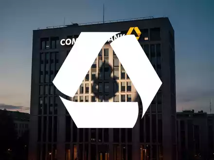 Ein beleuchtetes Commerzbank-Gebäude bei Dämmerung mit einem Schatteneffekt auf der Fassade, der Misstrauen andeutet. - Foto: über boerse-global.de