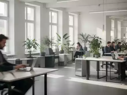 Ein minimalistischer Coworking Space in Berlin mit viel natürlichem Licht und verschwommenen Personen, die an Laptops arbeiten. - Foto: über boerse-global.de