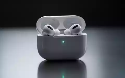 Apple AirPods Pro earbuds in their open charging case, subtly illuminated, on a reflective surface. - Foto: über boerse-global.de