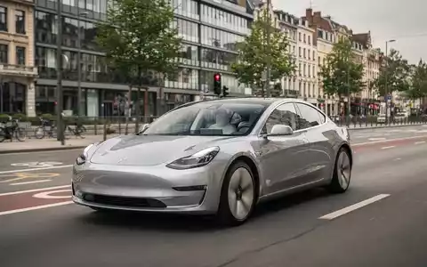 Ein autonom fahrendes Elektroauto auf einer modernen Straße in Brüssel, das FSD-Technologie und Automobilinnovation darstellt. - Foto: über boerse-global.de