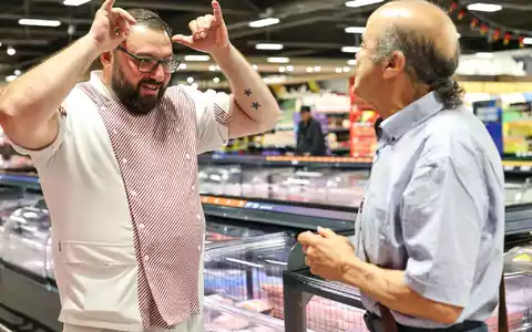 Metzger Yevgeniy Klibanov zeigt die Gebärde für «Rind».  - Foto: Daniel Löb/dpa