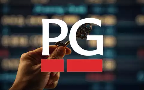 Nahaufnahme einer Hand, die einen goldenen Schlüssel hält, mit einer verschwommenen Aktienkursanzeige im Hintergrund. - Foto: über boerse-global.de