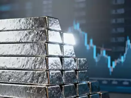Ein Stapel glänzender Silberbarren, die ein leichtes Licht reflektieren, mit einem unscharfen Hintergrund, der Daten andeutet. - Foto: über boerse-global.de